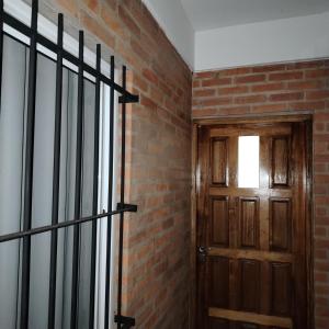 a room with a brick wall and a wooden door at Complejo Cambyreta in Encarnación