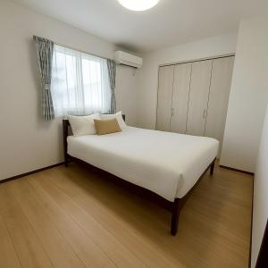 a bedroom with a large white bed and a window at Wstay in Ozu