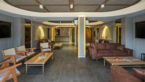 a lobby with couches and tables in a building at Monk Resort Hotel Beldibi in Kemer
