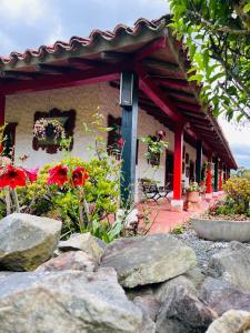 a house with a garden with rocks in front of it at Posada de Aquilino MC in Cucunubá