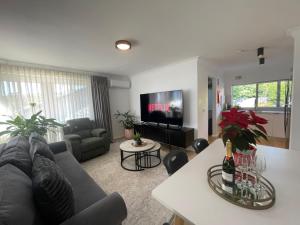 a living room with a couch and a tv at Guesthouse Nature Escape Sleeps up to 6 in Heathcote