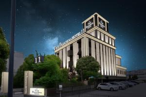 a white building with a clock tower on top at night at hotel the pasadena 11 funabashi in Funabashi