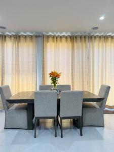 a dining room table with chairs and a vase of flowers on it at Peaceful Stay in Wyndham Vale
