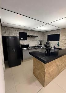 a kitchen with a black counter and a black refrigerator at Hermoso Departamento Moderno con alberca in Boca del Río