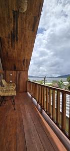 a balcony with a bench on a wooden deck at Teras Danu in Bedugul