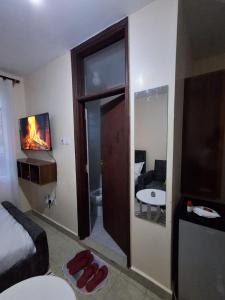a room with a bed and a living room with a fireplace at Machakos Town Studios in Machakos