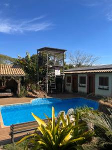 a house with a ladder next to a swimming pool at Suíte master - Hostel em Itupeva in Itupeva
