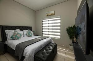una camera da letto con un letto grande e una finestra di Home Very Close To CBD a Gaborone