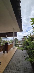 an outdoor patio with a bench and an umbrella at Teras Danu in Bedugul