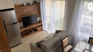 a living room with a couch and a television at Sobrado com Arcondicionado, tomada 220V para veículo elétrico e Wi-Fi em Coroados Guaratuba in Guaratuba +17 photos