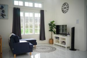 a living room with a blue chair and a tv at Pilla Villa Purwokerto in Purwokerto