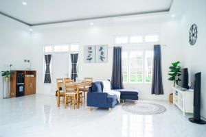 een woonkamer met een blauwe stoel en een tafel bij Pilla Villa Purwokerto in Purwokerto +14 foto's