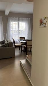 a living room with a couch and a table at Sobrado com Arcondicionado, tomada 220V para veículo elétrico e Wi-Fi em Coroados Guaratuba in Guaratuba