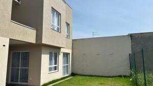 a building with a grass yard in front of it at Sobrado com Arcondicionado, tomada 220V para veículo elétrico e Wi-Fi em Coroados Guaratuba in Guaratuba