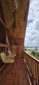 a wooden balcony with chairs and a table on it at Teras Danu in Bedugul