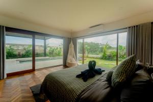 una camera da letto con un letto grande e una grande finestra di Newly Built Villa - Rice Fields & Tranquil Getaway a Tumbak Bayuh Altre 75 foto