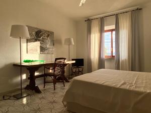 a bedroom with a bed and a desk and a table at Terrazza sull Argentario in Ansedónia