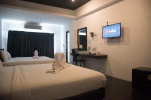 a hotel room with two beds and a flat screen tv at Azz Hotel in Chiang Mai +99 photos