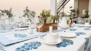 a table with a blue and white table cloth with wine glasses at The Niruma Villa in Udaipur
