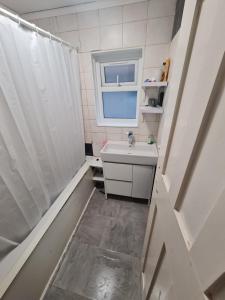 a small bathroom with a sink and a window at Guesthouse 3 in Tilbury
