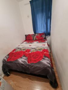 a bed with red roses on it in a room at Guesthouse 3 in Tilbury