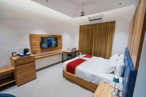 a hotel room with a bed and a television at Nes-Terns in Coimbatore