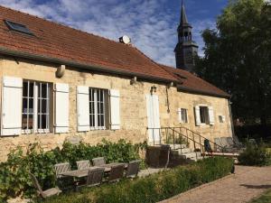 a stone building with two benches in front of it at L'Escale en Bourgogne in Saint-Rémy