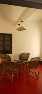 a dining room with a table and chairs and a chandelier at Casa Shanti in Kannur
