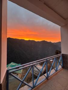 a sunset from the balcony of a house at The Blue Mont Sojha Jibhi in Shoja +42 photos
