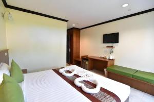 a hotel room with a bed and a television at The Green Hotel in Ko Lipe