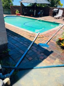 a swimming pool with a hose on the ground at Ezendalo Guest House in Pinetown