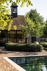 een zwembad voor een gebouw met een klokkentoren bij Ghent Marriott Hotel in Gent