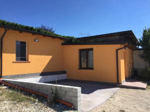a yellow house with a patio in front of it at casetta dell'Alpino in LʼAquila