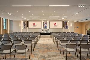 a large room with rows of chairs and screens at Ghent Marriott Hotel in Ghent