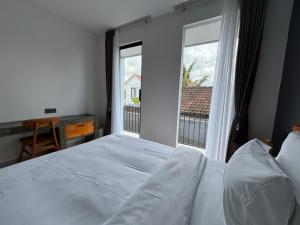 una camera da letto con un letto e una grande finestra di Laziela Guest House a Munggu