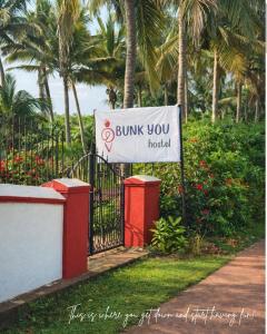 un cartello su una recinzione che dice "Burning you hospital" di Bunk You Hostel a Gokarna