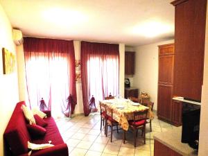 sala de estar con mesa y sofá rojo en Casa Teresa, en Perugia