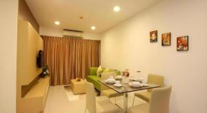 un soggiorno con tavolo e divano verde di Landmark Residence a Ban Khlong Sanam Phli