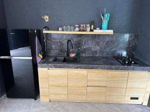 una cucina con lavandino e piano di lavoro nero di Laziela Guest House a Munggu