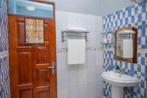 a bathroom with a sink and a toilet and a door at Palm Haven Furnished Apartments in Bweyogerere +28 photos