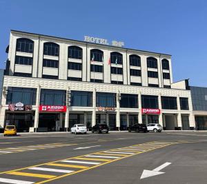a large white building with cars parked in front of it at Pandora Hotel in Samarkand