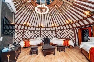 een kamer met 2 bedden en een tafel in een yurt bij Blue Spot Resort in Yoliin Hural +54 foto's