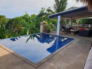 een zwembad naast een huis bij Pink House in Lamai