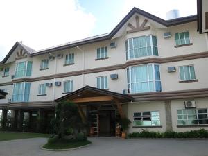 een groot wit gebouw met een ingang bij Chocolate and Berries Hotel in Suliban