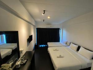 a hotel room with two beds and a mirror at Azz Hotel in Chiang Mai