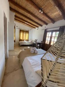 een slaapkamer met 2 bedden en een hangmat. bij Capec Alojamiento in Tilcara +14 foto's
