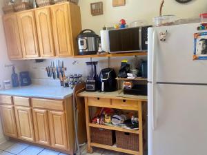 a kitchen with a white refrigerator and wooden cabinets at Woodside room in Sunnyside