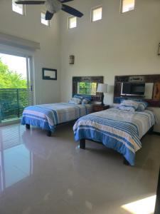 a bedroom with two beds and a ceiling fan at Casa Flamingos Coco in Mezcales +62 photos