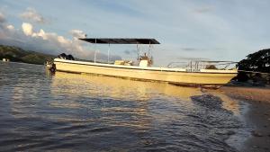 a boat sitting on the shore of a body of water at The houmstay pangsing in Mataram +1 photo