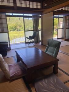 a living room with a wooden table and chairs at 自宅民泊The 34Sassysサッシーズ萩市佐々並 in Yamaguchi